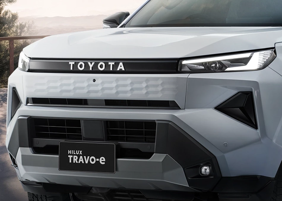 Hilux Travo-e: กระจังหน้าด้านบนสีเดียวกับตัวรถ ดีไซน์พิเศษเฉพาะ Travo-e ด้านล่าง สีดำ ตกแต่งด้วยสีเงิน